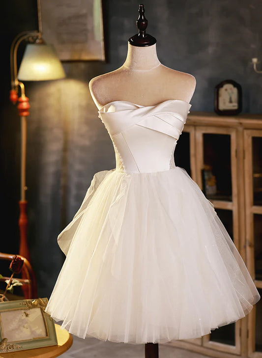 Model wearing an elegant ivory tulle and satin short strapless dress with a sweetheart neckline.