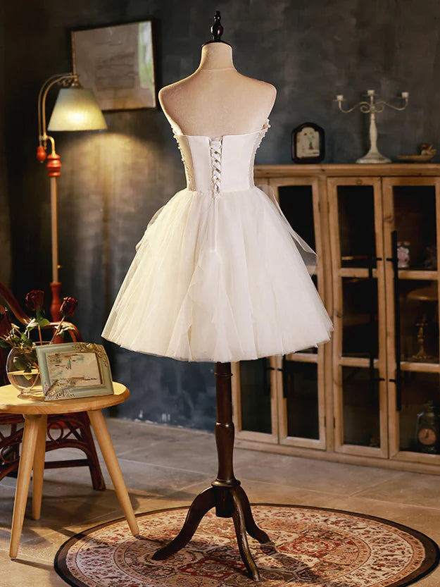 Back view of the ivory short party dress, showcasing the delicate tulle skirt.