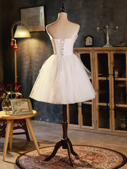 Back view of the ivory short party dress, showcasing the delicate tulle skirt.