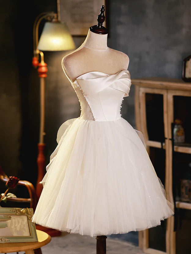 Close-up of the ivory graduation dress, showing the fabric texture and sweetheart neckline detail.