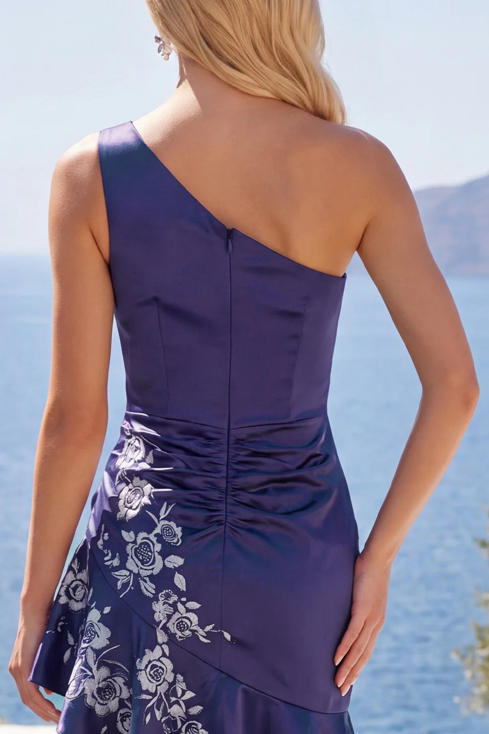 Full-length view of a model posing in the elegant navy blue one-shoulder dress.