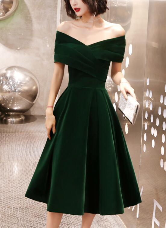 Model wearing a green velvet off-shoulder tea-length dress.