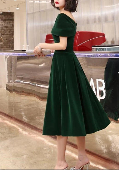 Elegant green velvet tea-length dress with off-shoulder neckline.