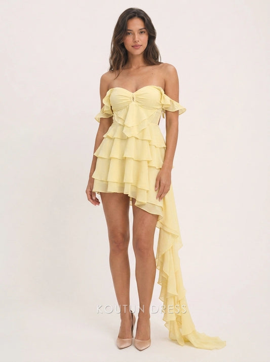 Model wearing a pale yellow off-shoulder sweetheart high-low homecoming dress with ruffled tiers.
