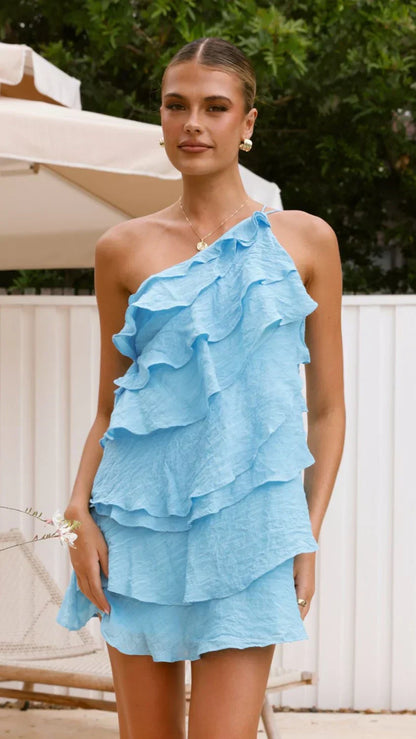 Close-up of the tiered ruffles and one-shoulder detail on the light blue dress.