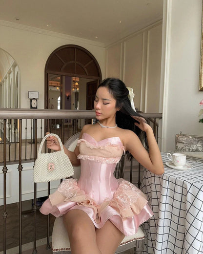 Side view of pink strapless corset dress with ruffled skirt.