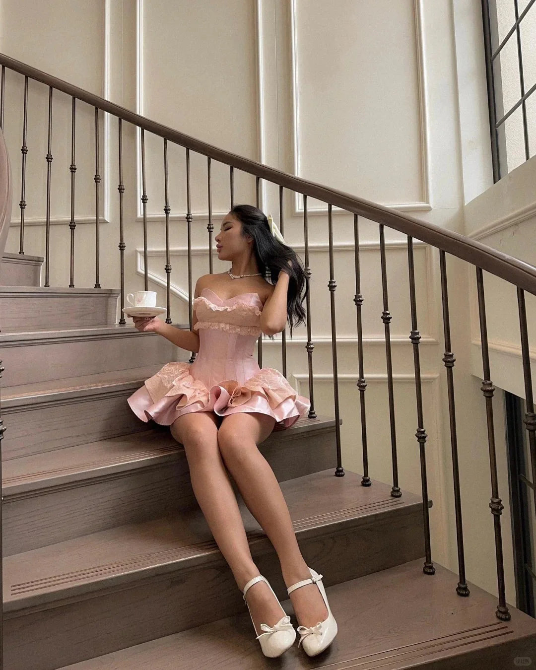 Close-up of lace trim and ruffled layers on pink dress.