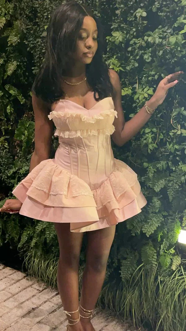 Model wearing pink strapless corset dress, full length.