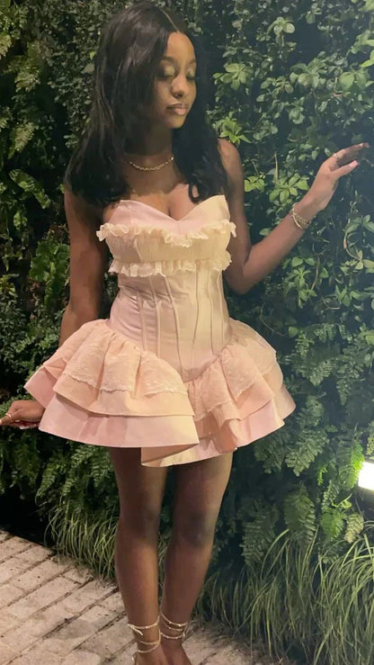 Model wearing pink strapless corset dress, full length.