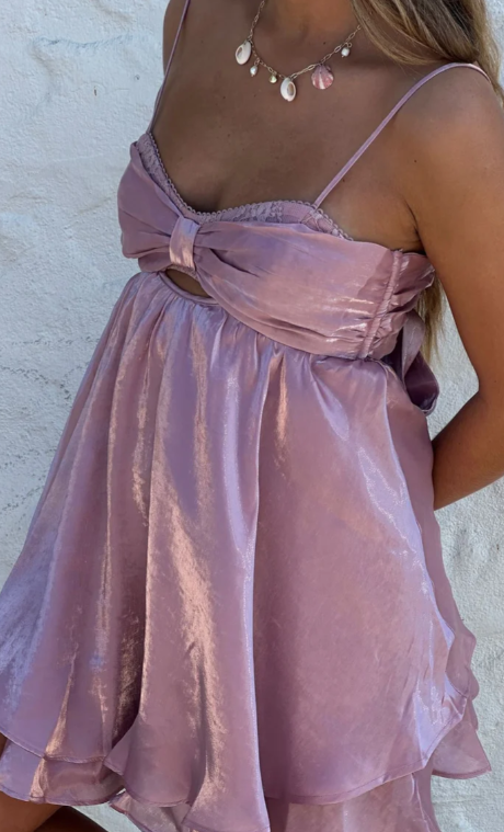 Model wearing a rosy glow satin mini dress with spaghetti straps.