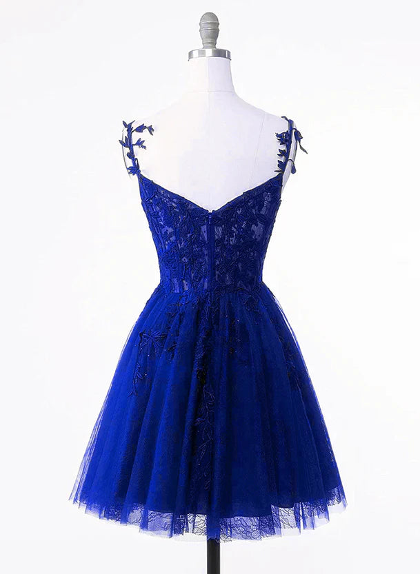 Back view of a royal blue short formal dress featuring lace details and a flowing tulle skirt.