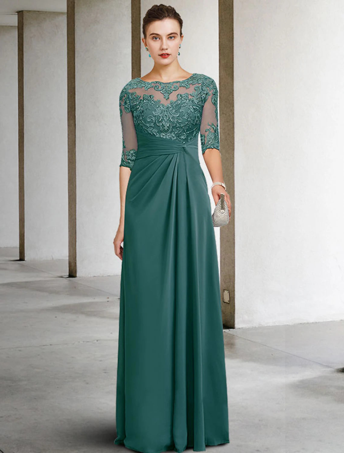 Woman in a navy sheath mother of the bride dress with jewel neck and short sleeves.