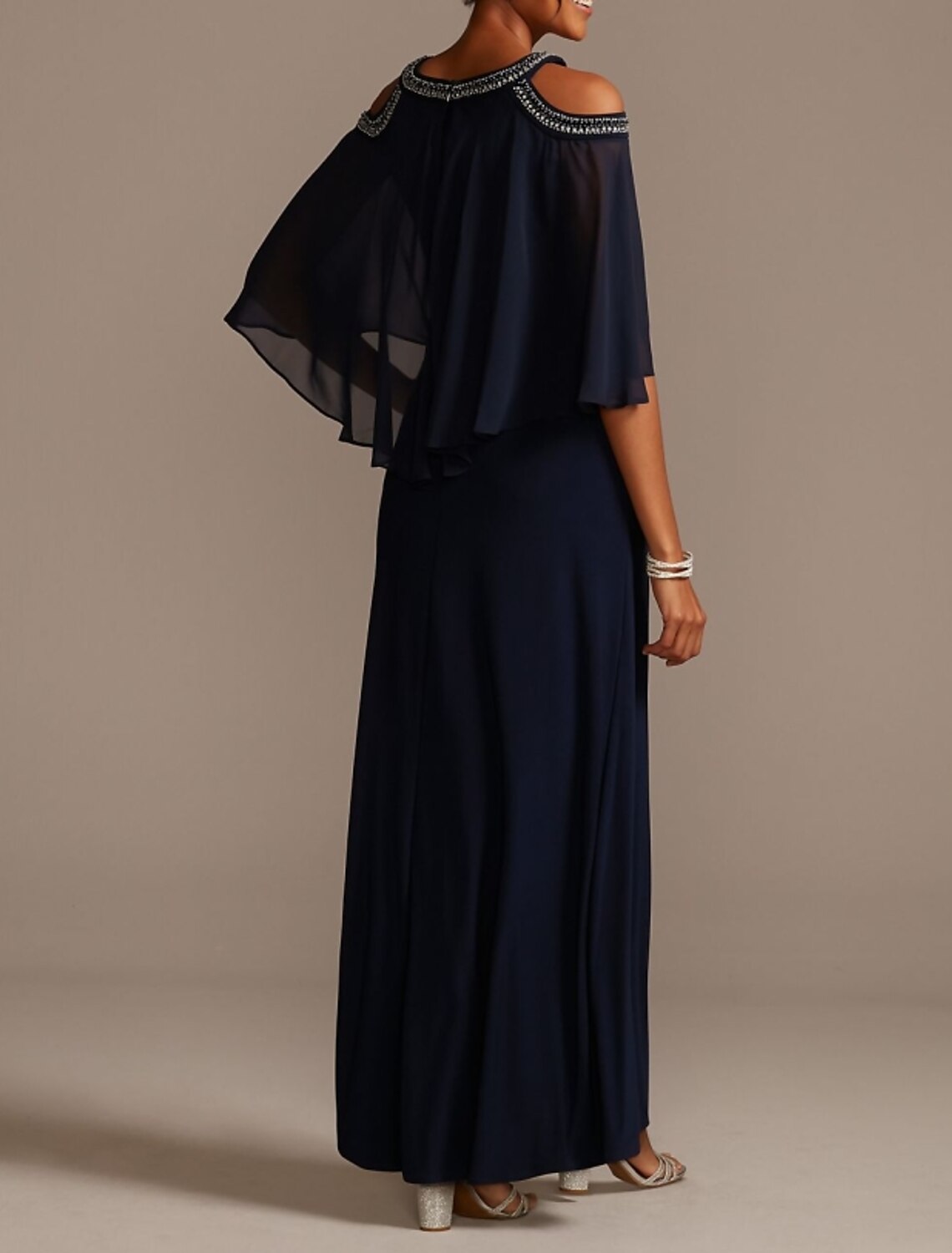 Back view of a woman in a floor-length beaded chiffon dress.