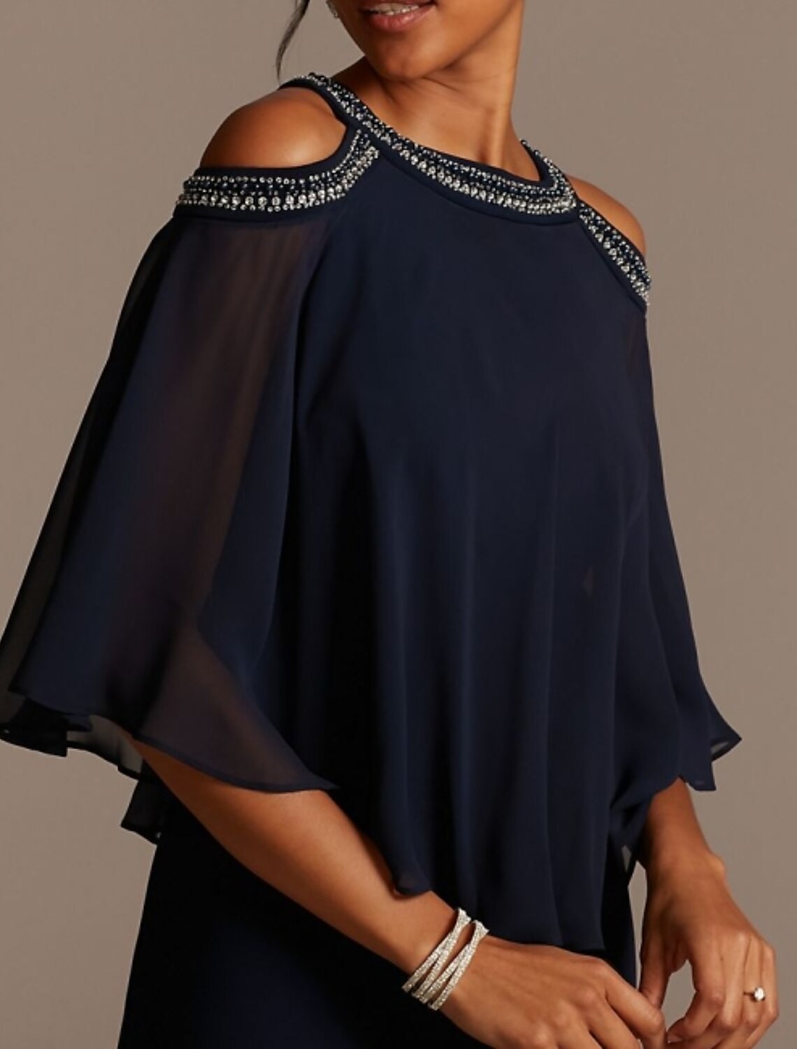 Side profile of a woman in a half-sleeve formal gown with sequins.