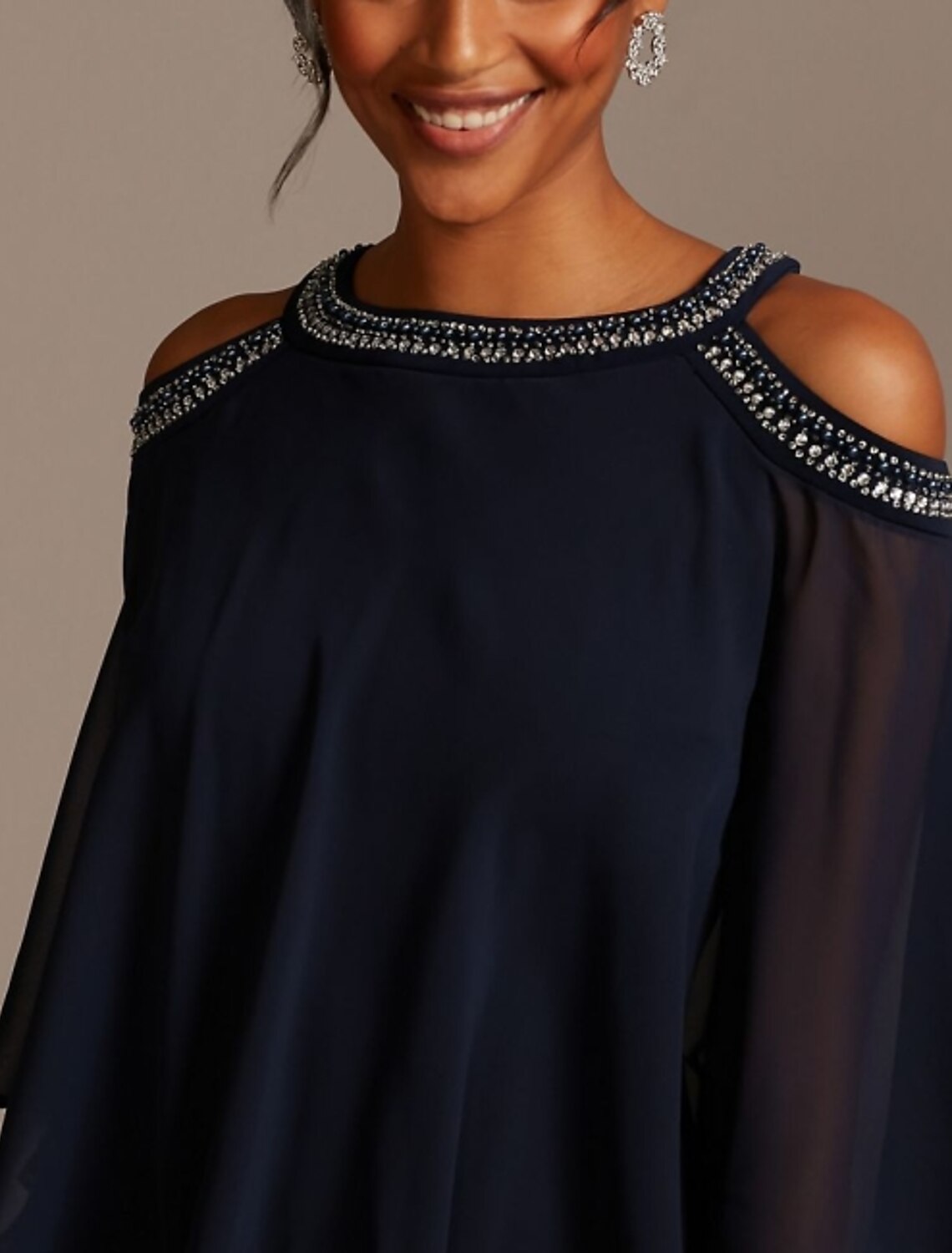 Close-up of the jewel neck and beaded details on a navy dress.