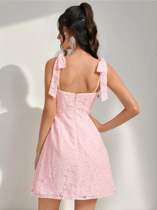 Back view of white lace mini sheath dress, highlighting the elegant bow.