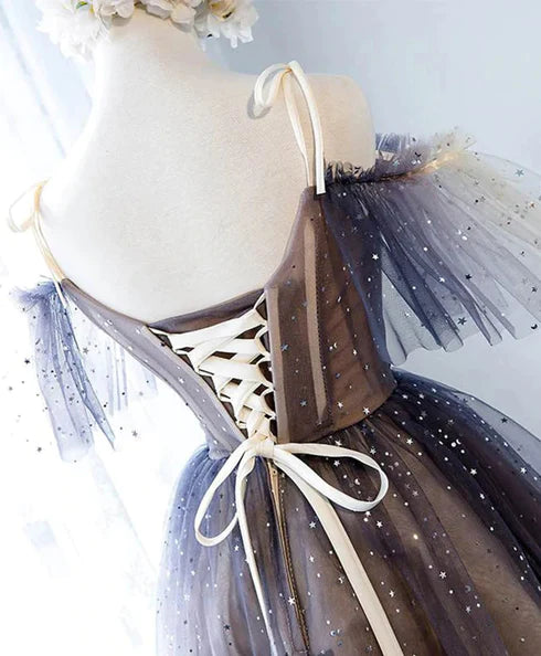 Close-up of the V-neckline and lace details on a short tulle dress.