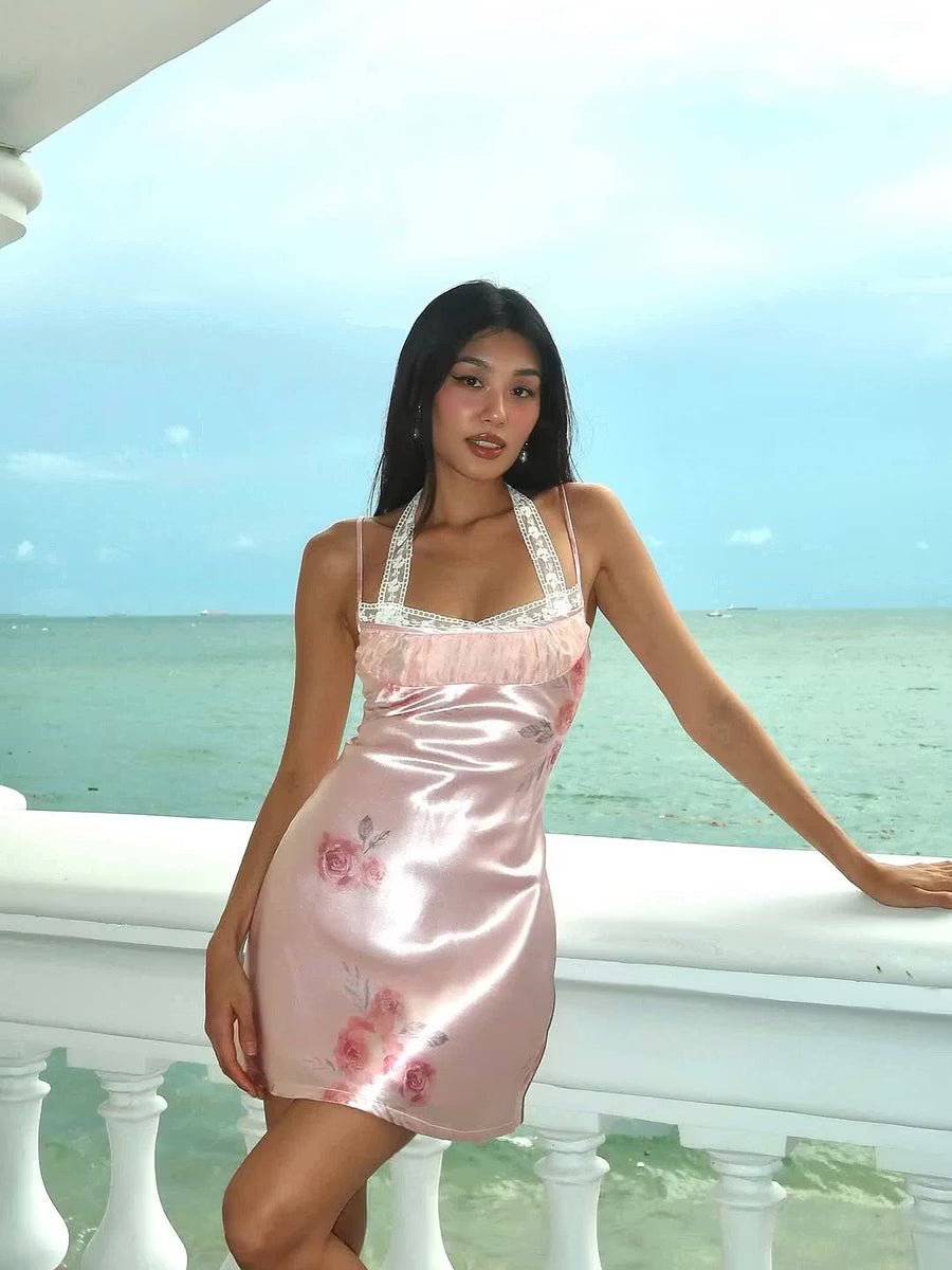 Side view of elegant blush pink floral mini dress with lace trim.