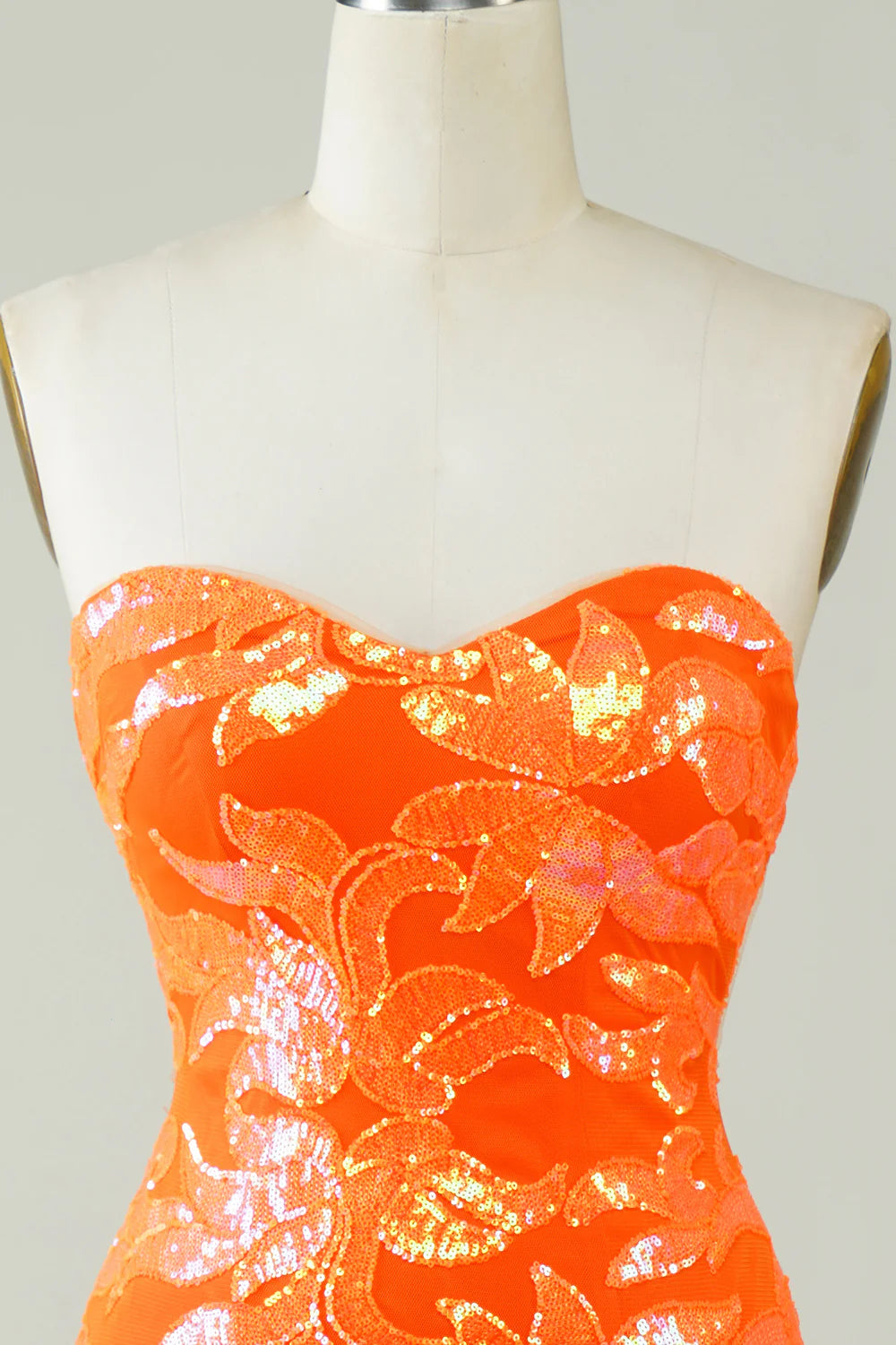 Close-up of the fabric and fit of the orange strapless dress.