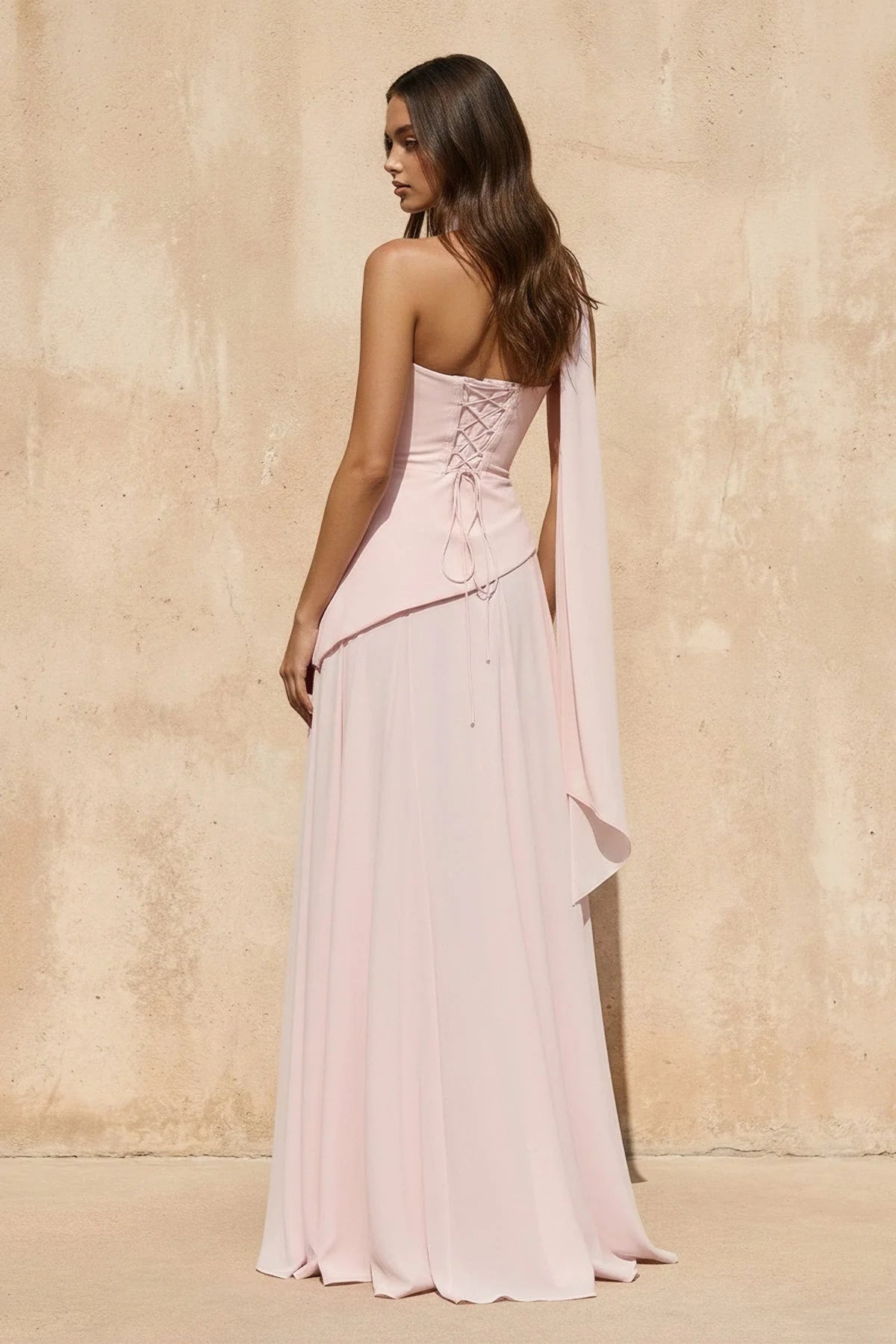 Side view of a model wearing the flowy chiffon evening dress with neck sash.