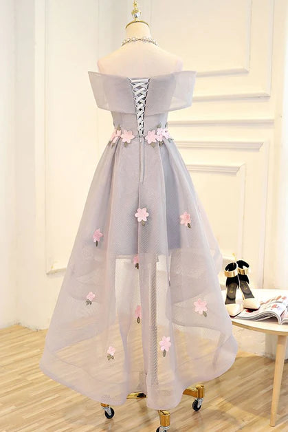 Close-up of delicate floral embellishments on light grey tulle fabric.