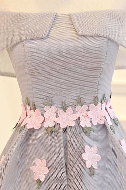 Back view of an elegant light grey high-low tulle party dress.