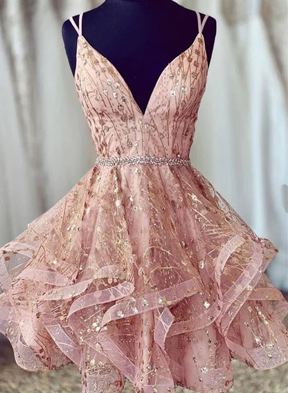 Model wearing a pink tulle short prom dress with straps and lace-up back.