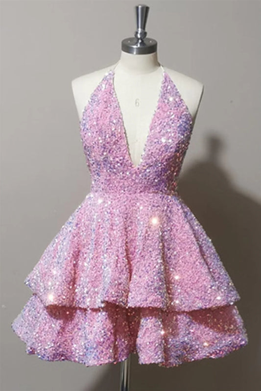 Model wearing a pink tiered sequin short homecoming dress with a deep V-neck and halter neckline.