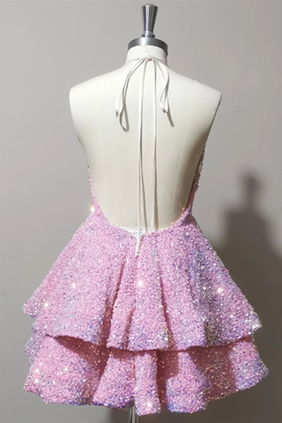 Close-up of the sparkling tiered sequin fabric on a pink short dress.