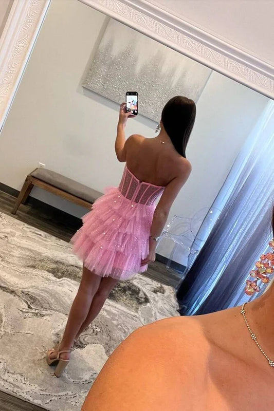Side view of pink tiered strapless A-line homecoming dress.