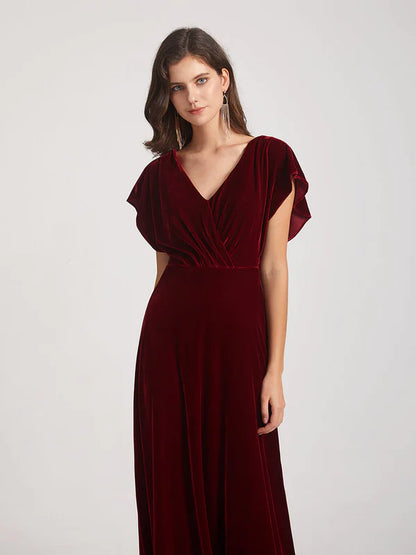 Front view of a woman in an elegant V-neck flutter sleeve velvet dress.