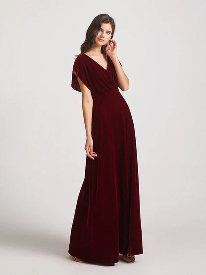 Side view of a woman posing in a velvet bridesmaid dress with flutter sleeves.