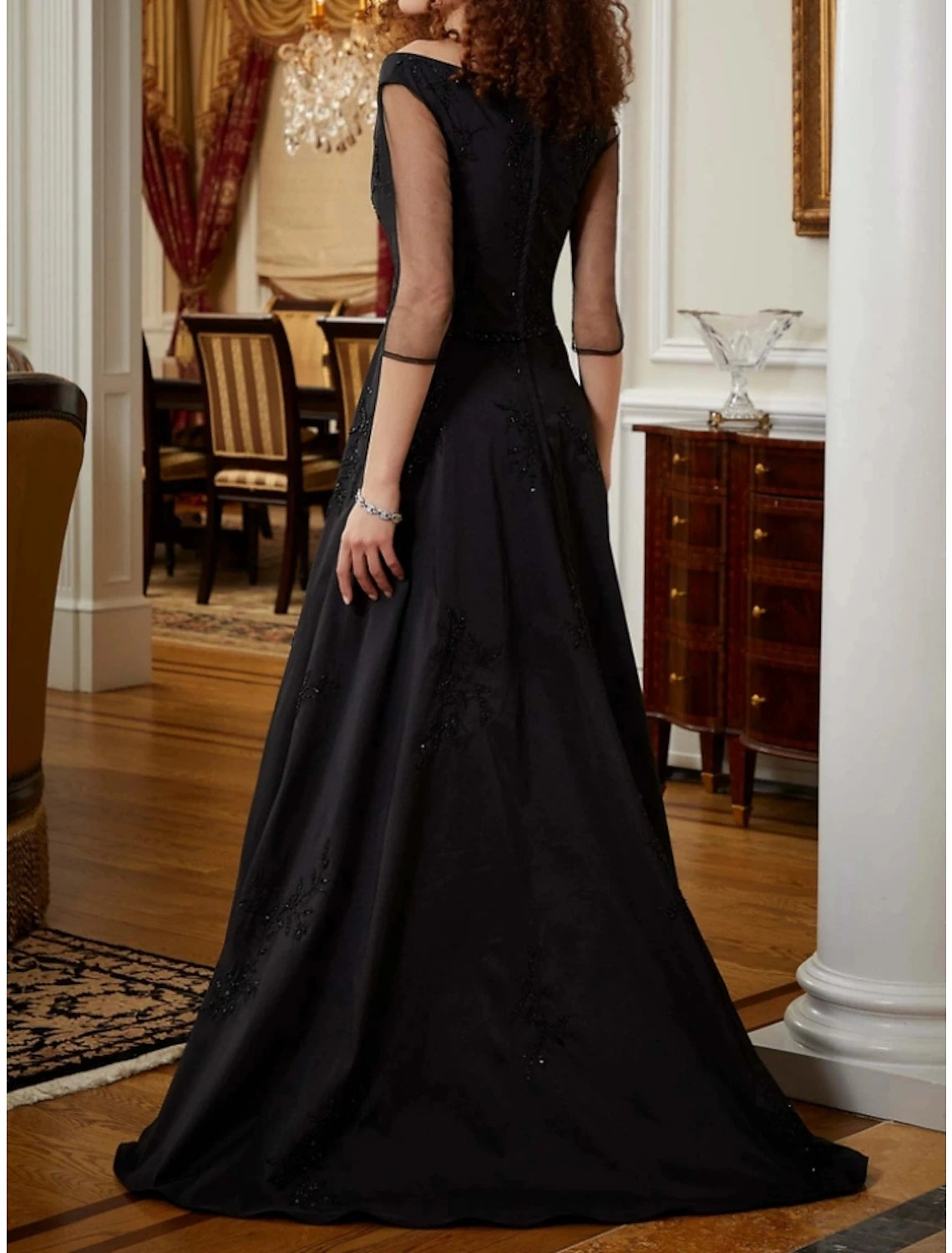 Close-up of V-neckline, half sleeves, and sequin detail on stretch satin jumpsuit.