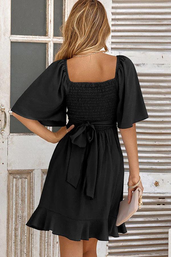 Close-up of the ruffled waist detail on the V-neck mini dress.
