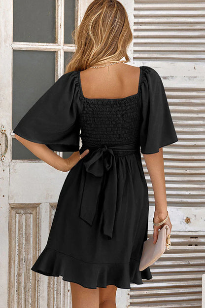 Close-up of the ruffled waist detail on the V-neck mini dress.