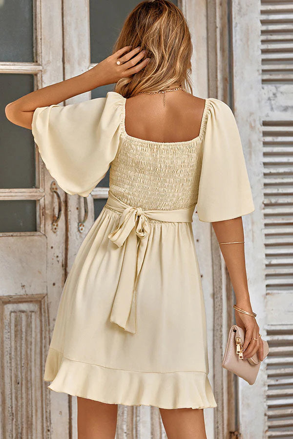 Full length view of the solid color V-neck ruffled waist mini dress.