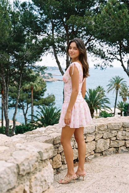 Side view of a pink floral chiffon mini dress with tie straps and a flared skirt.