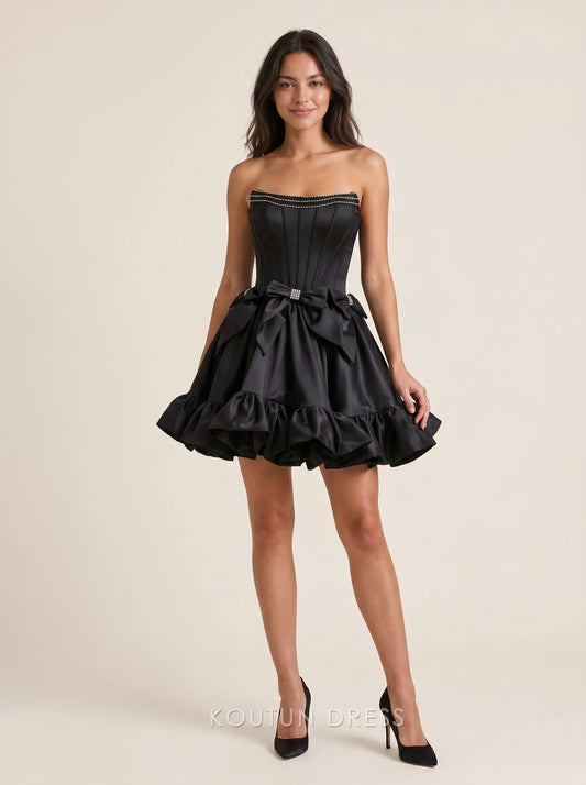 Black strapless satin homecoming dress with rhinestone trim and bow detail.