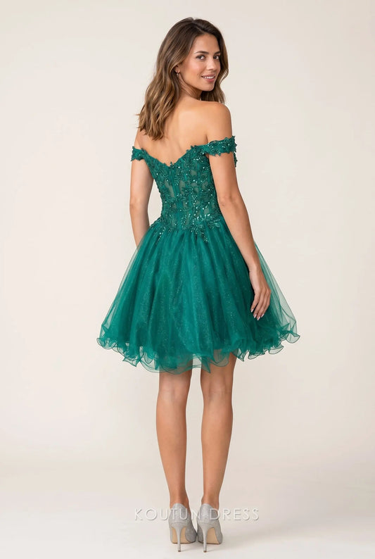 Model wearing an emerald green off-shoulder mini homecoming dress with a ruffled tulle skirt, side view.