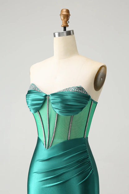 Close-up of beading and glitter on a dark green dress.