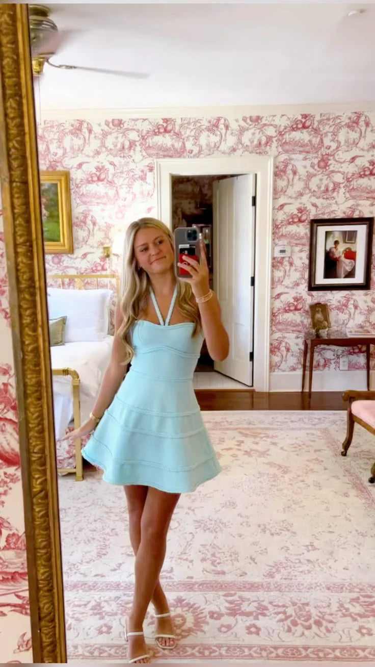 Model wearing a Koutun A-Line short homecoming dress with halter neck, tiered ruffles, and braided trim.