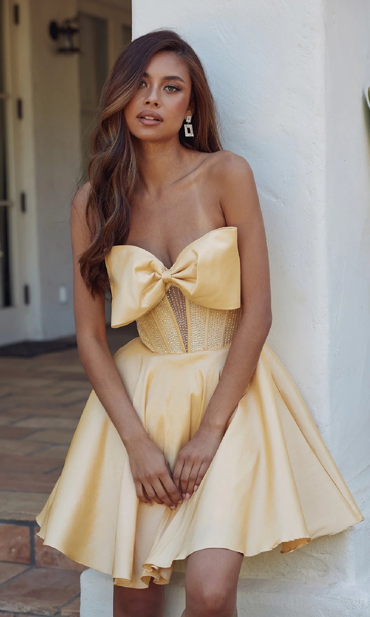 Full view of the yellow strapless A-line homecoming dress with a satin skirt.