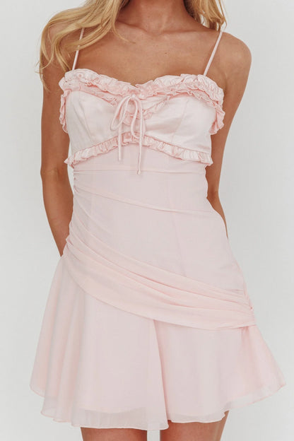 Close-up of the ruffled sweetheart neckline and spaghetti straps on the pink dress.