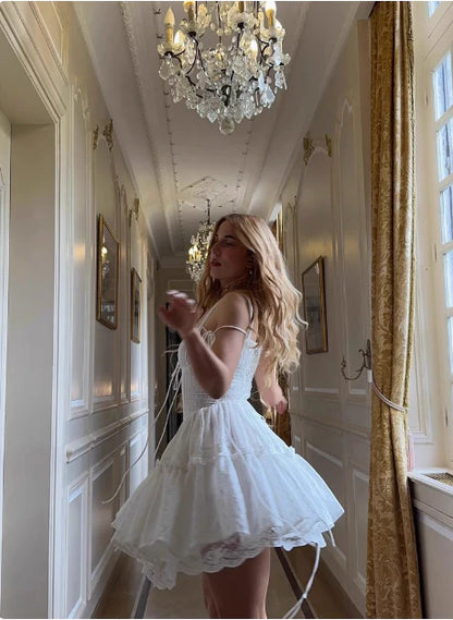 Back view of the white lace corset dress, showing the lace-up detail and tiered ruffled skirt.