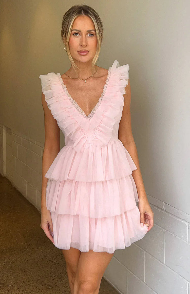Model in blush pink ruffled tulle V-neck tiered homecoming dress.