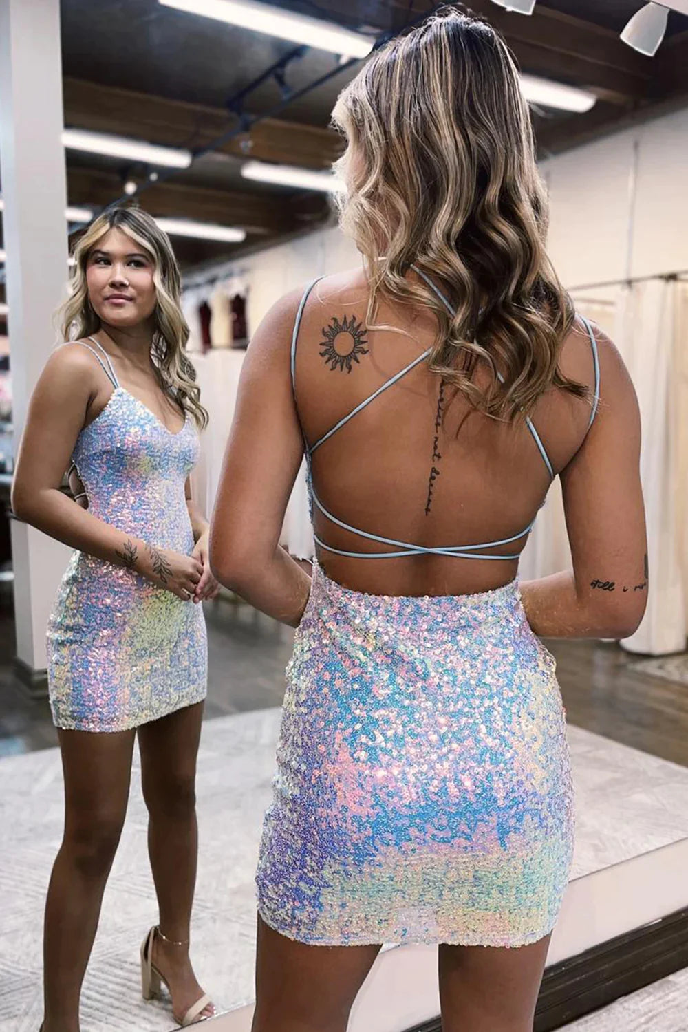 Back view of white sequin dress, showing criss-cross strap detail.