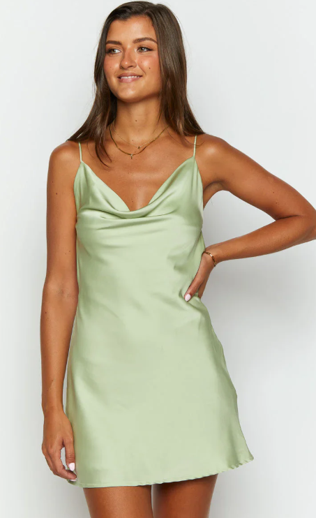 Model in a sleek light satin spaghetti strap mini dress.