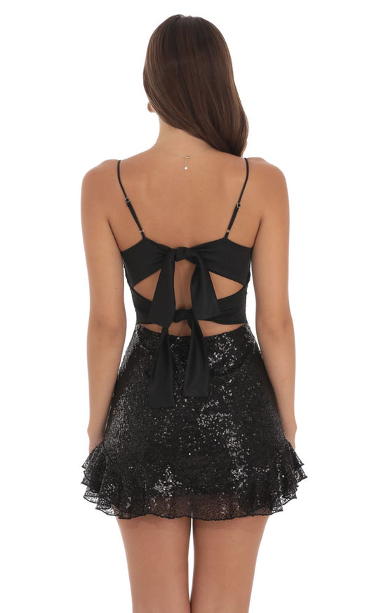 Back view of the black sequin mini dress, highlighting the large satin bow detail.
