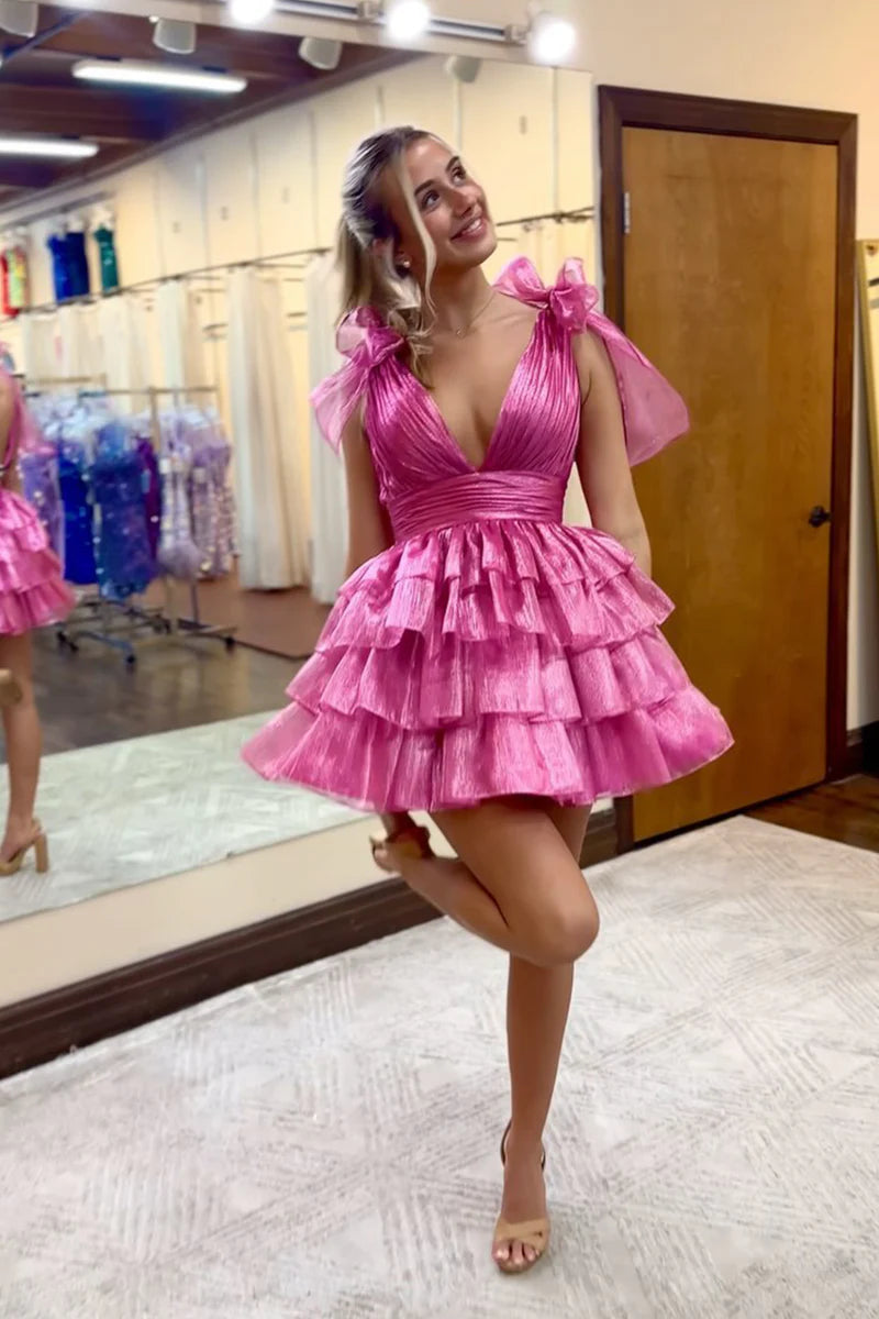 Back view of a model in a sparkling A-line tiered short homecoming dress with a bow.