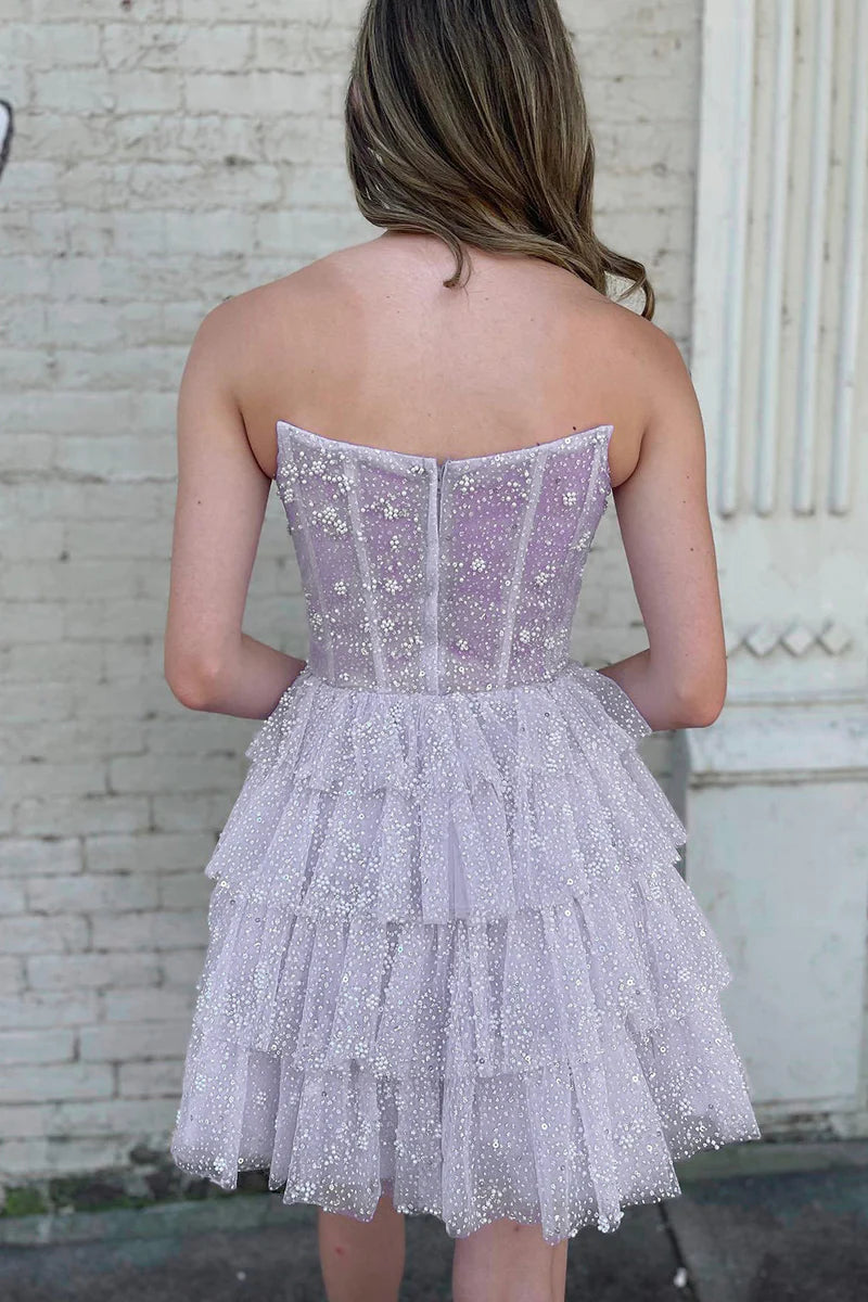 Close-up of the sparkling fabric and tiered skirt of the dress.